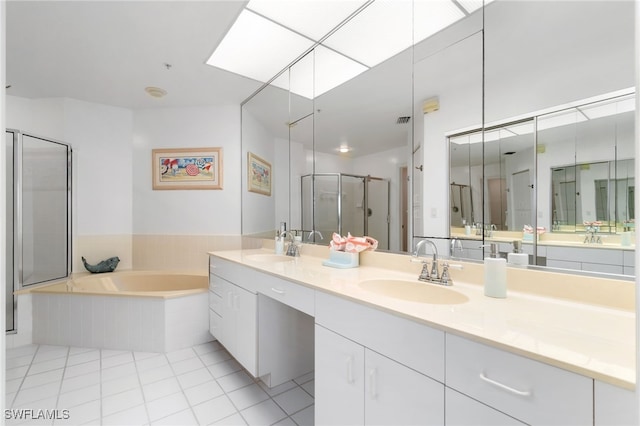 bathroom with tile patterned floors, a skylight, vanity, and shower with separate bathtub