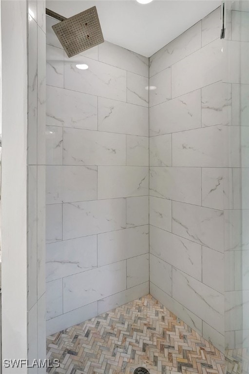 bathroom featuring a tile shower and parquet floors