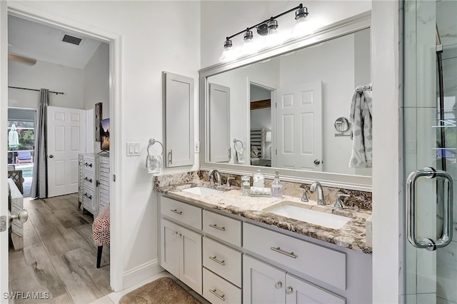 bathroom featuring wood-type flooring, vanity, and a shower with shower door