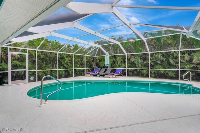 view of pool featuring glass enclosure and a patio area