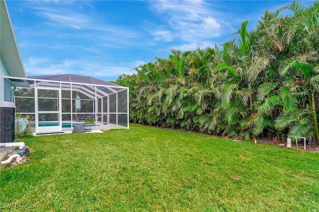 view of yard featuring a lanai and central air condition unit