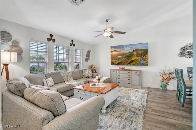 living room with ceiling fan and light wood-type flooring