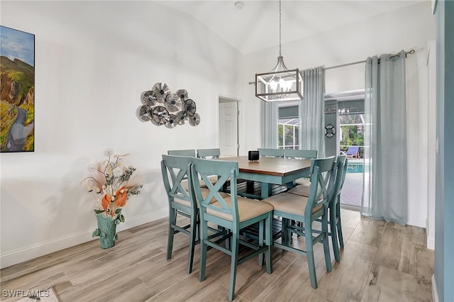 dining space with a chandelier, lofted ceiling, and light hardwood / wood-style flooring