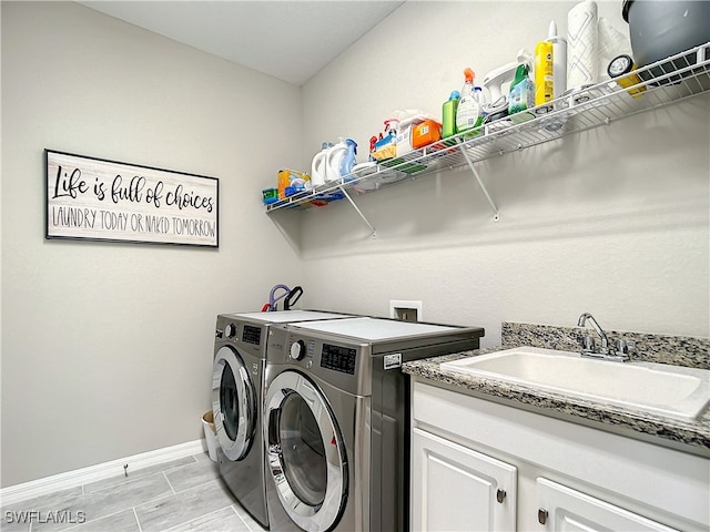 laundry room with cabinets, separate washer and dryer, and sink