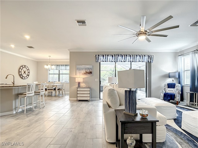 bedroom featuring ceiling fan with notable chandelier, light hardwood / wood-style floors, ornamental molding, and multiple windows