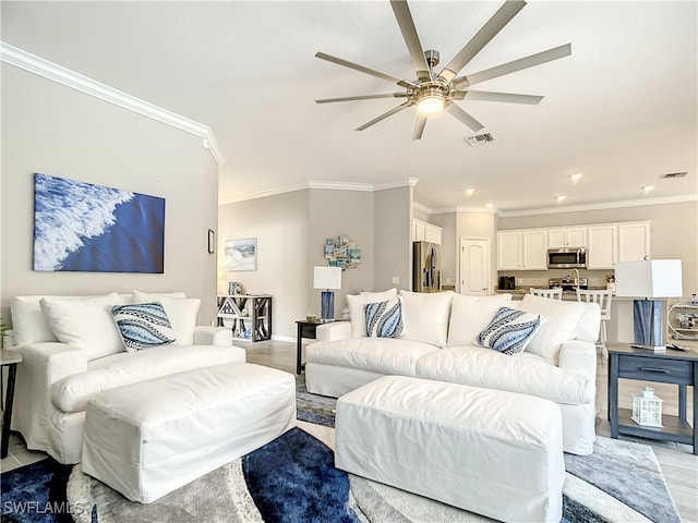 living room featuring crown molding, ceiling fan, and light wood-type flooring