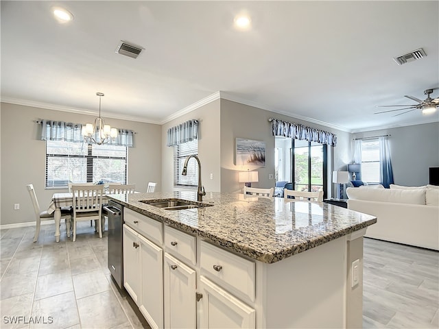 kitchen with light stone counters, sink, a center island with sink, white cabinets, and hanging light fixtures