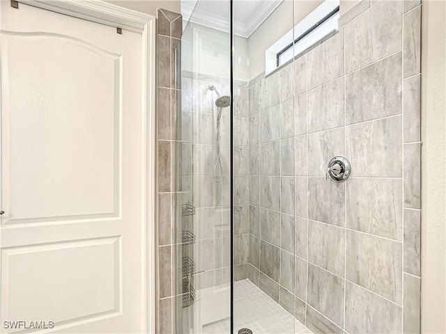 bathroom featuring tiled shower and ornamental molding