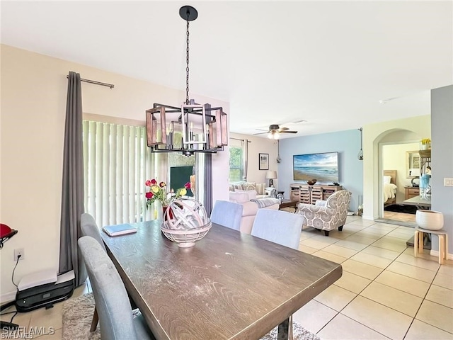 dining space featuring light tile patterned floors and ceiling fan with notable chandelier