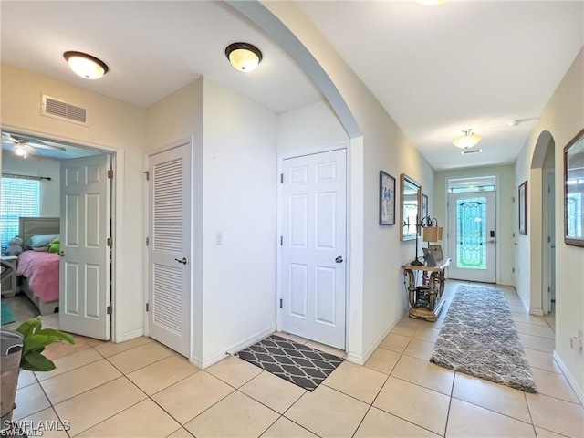 tiled foyer featuring ceiling fan