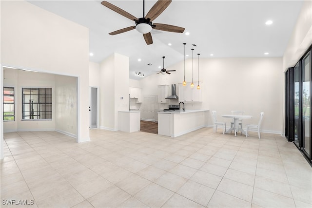 kitchen featuring kitchen peninsula, decorative light fixtures, white cabinetry, and a wealth of natural light