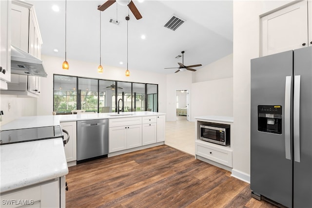 kitchen featuring ventilation hood, white cabinets, sink, decorative light fixtures, and stainless steel appliances