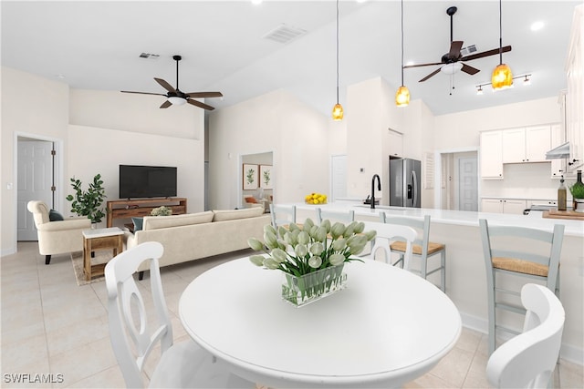 tiled dining room featuring ceiling fan and high vaulted ceiling