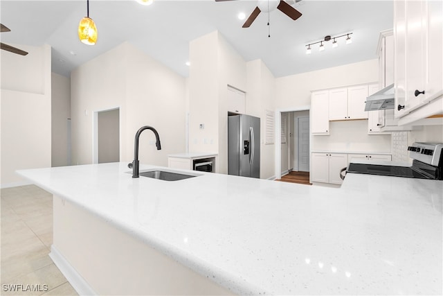 kitchen featuring stainless steel fridge, sink, decorative light fixtures, white cabinets, and range