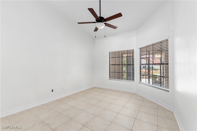 unfurnished room with light tile patterned floors, ceiling fan, and a high ceiling