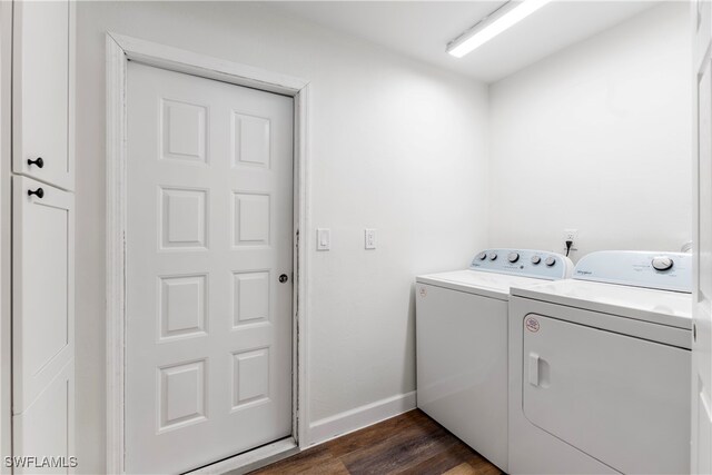 laundry area featuring cabinets, washing machine and dryer, and dark wood-type flooring