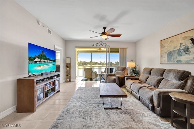 living area featuring light tile patterned floors, ceiling fan, visible vents, and baseboards