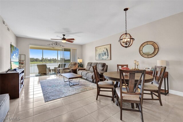 tiled living room featuring ceiling fan with notable chandelier