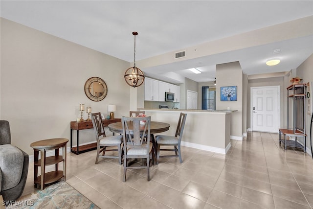 dining space with light tile patterned floors and an inviting chandelier