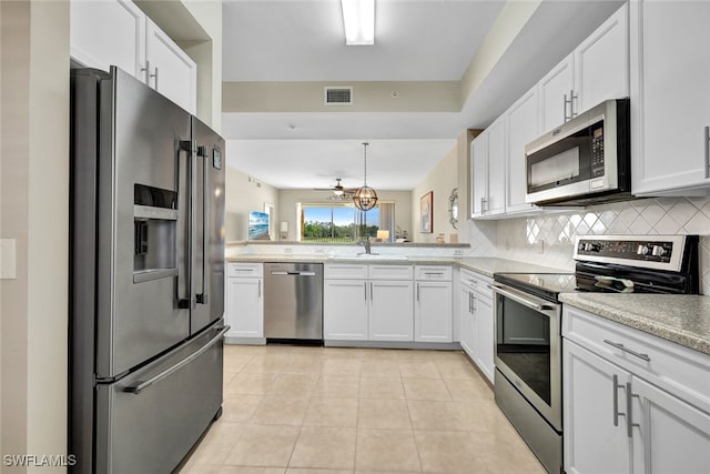 kitchen featuring appliances with stainless steel finishes, backsplash, and white cabinetry