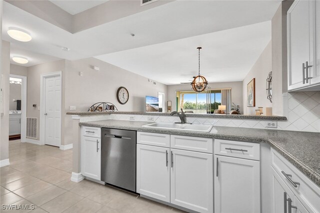 kitchen featuring white cabinets, decorative backsplash, stainless steel dishwasher, and sink