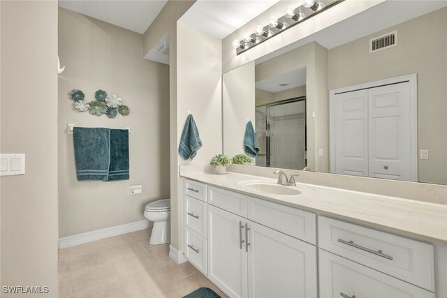 bathroom featuring toilet, vanity, tile patterned floors, and walk in shower