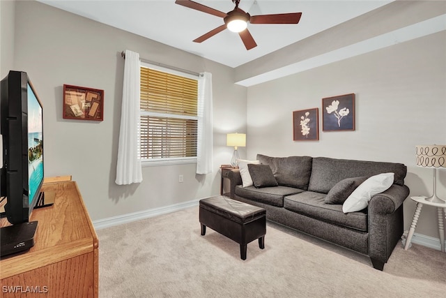 living area featuring carpet flooring, a ceiling fan, and baseboards