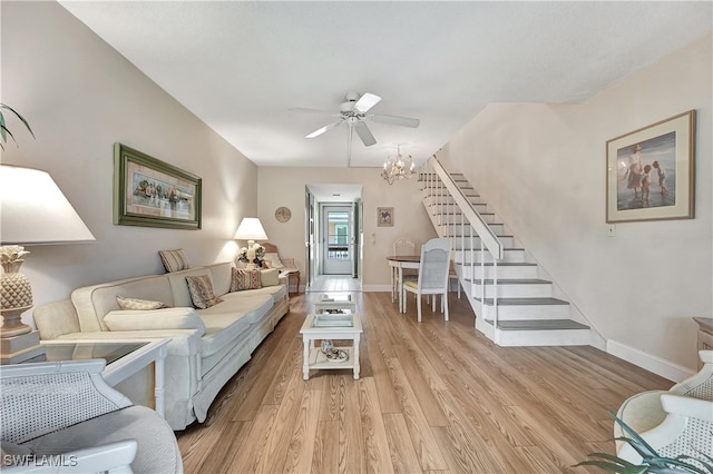 living room featuring ceiling fan with notable chandelier and light hardwood / wood-style floors