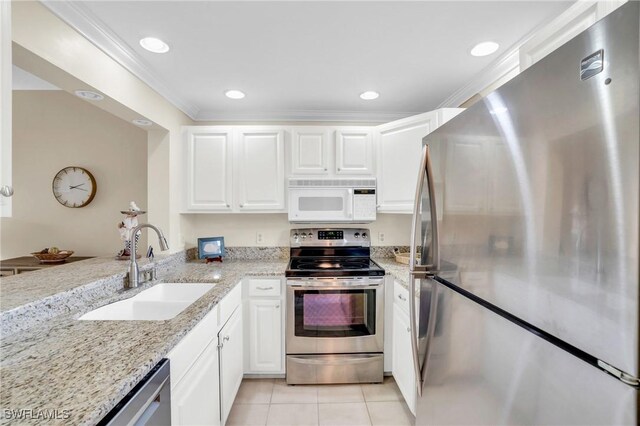 kitchen with light stone countertops, appliances with stainless steel finishes, sink, and white cabinets