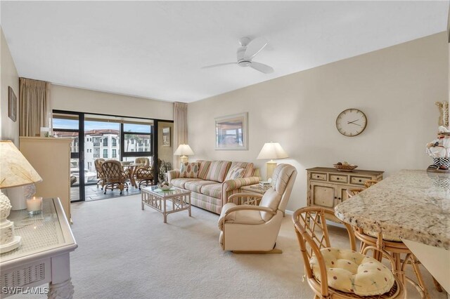 carpeted living room with ceiling fan