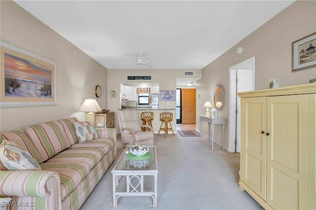 carpeted living room featuring ceiling fan