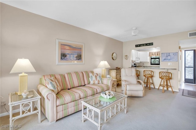 carpeted living room with ceiling fan