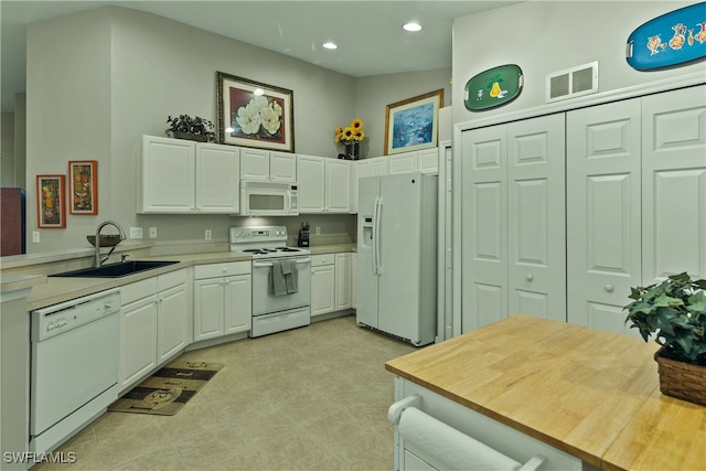 kitchen featuring kitchen peninsula, white appliances, sink, white cabinets, and lofted ceiling