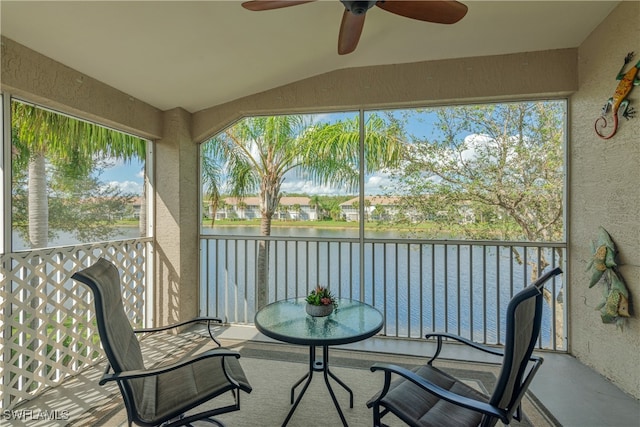 sunroom / solarium featuring ceiling fan, a water view, and lofted ceiling