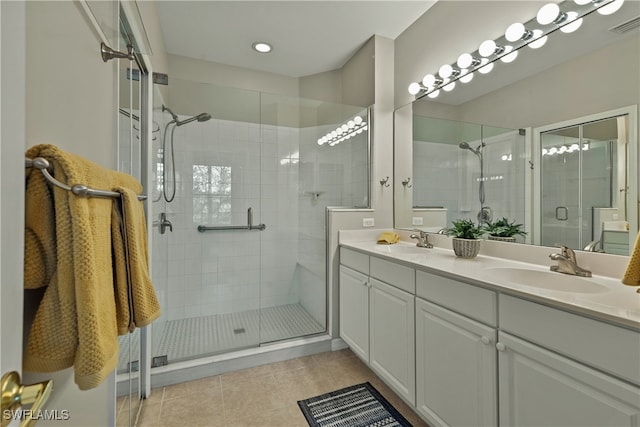 bathroom with tile patterned floors, vanity, and a shower with door