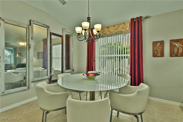 dining space featuring a wealth of natural light, light tile patterned floors, lofted ceiling, and a notable chandelier