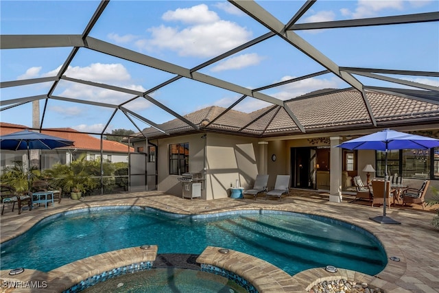 exterior space featuring a lanai, a patio, and a pool with hot tub