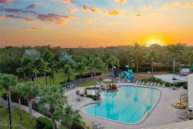 pool at dusk with a patio area