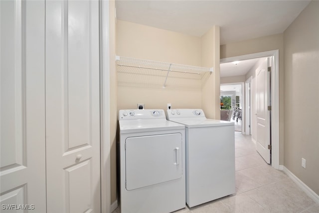 laundry area featuring washing machine and dryer and light tile patterned floors