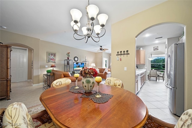 dining area with light tile patterned floors and ceiling fan with notable chandelier