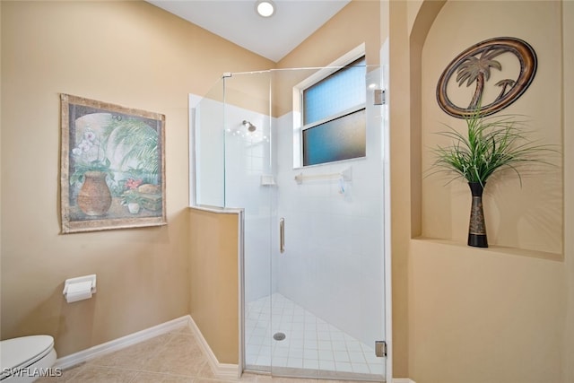 bathroom with tile patterned flooring, toilet, and a shower with shower door