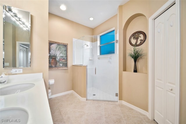 bathroom with tile patterned flooring, vanity, toilet, and a shower with door