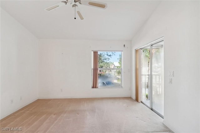 spare room with light carpet, ceiling fan, and vaulted ceiling