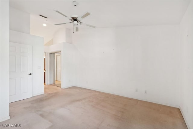 carpeted spare room featuring vaulted ceiling and ceiling fan