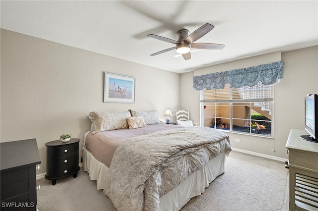 bedroom with ceiling fan and light colored carpet