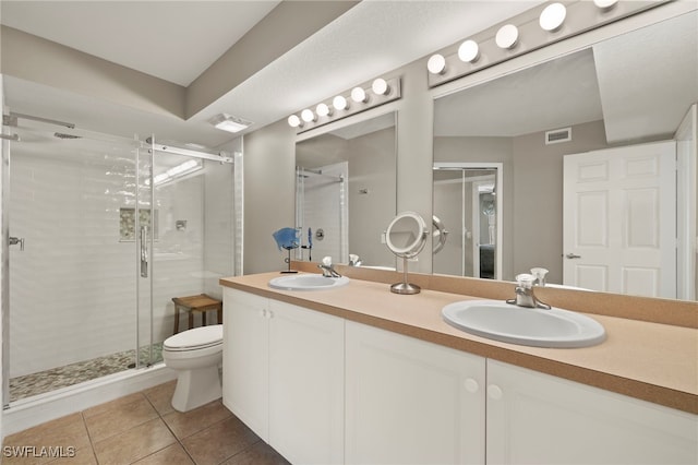 bathroom with tile patterned flooring, vanity, toilet, and an enclosed shower