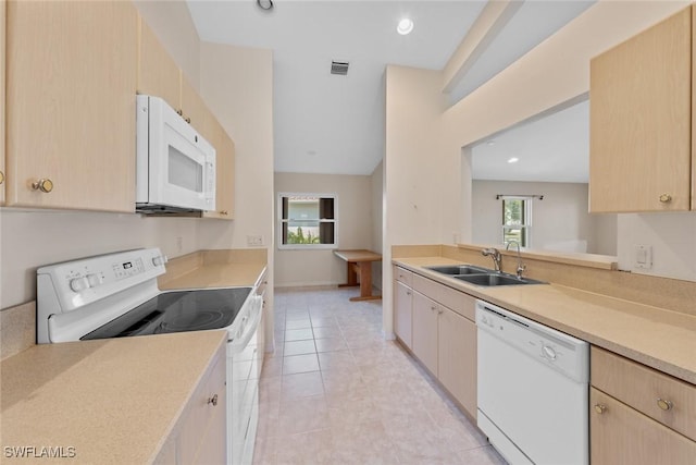 kitchen featuring light brown cabinetry, sink, light tile patterned flooring, and white appliances