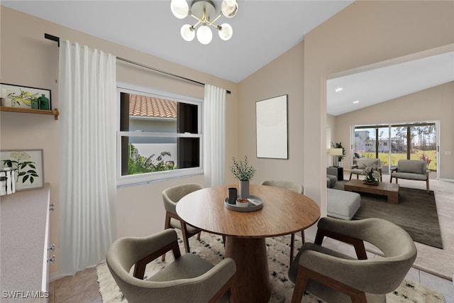 dining area featuring light tile patterned flooring, vaulted ceiling, and an inviting chandelier