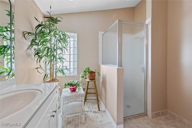 bathroom with a shower with door, vanity, vaulted ceiling, and tile patterned flooring