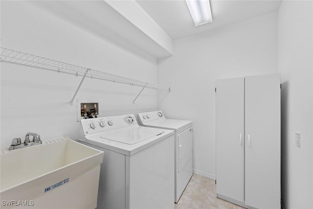 laundry room featuring washing machine and dryer, light tile patterned floors, and sink